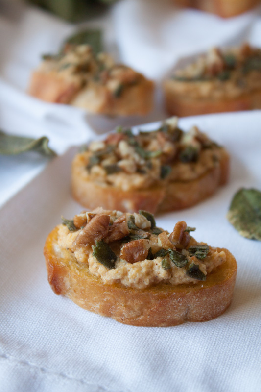 Spiced Autumn Crostini - a perfect fall appetizer or holiday appetizer! From Seriously Delish cookbook by Jessica Merchant, this crostini recipe is topped with mascarpone and pumpkin, fried sage, and toasted nuts!