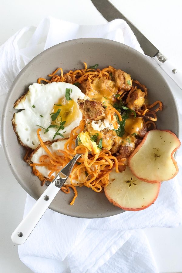 Healthy Sausage Egg and Cheese Breakfast Bowl with Curly Sweet Potato Fries - Make curly baked shoe string sweet potato fries with a spiralizer, and use those as the base for a breakfast bowl with fried eggs, crumbled breakfast sausage, and cheddar cheese! 