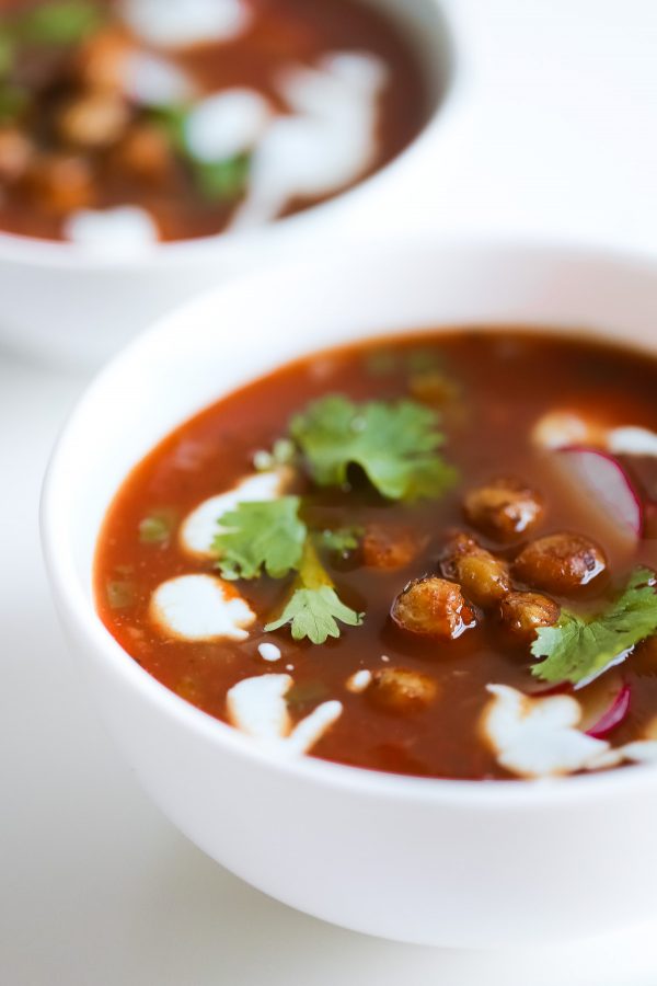 Vegetarian Tortilla Soup Recipe with Chili Roasted Chickpeas! A flavor powerhouse! This vegetarian soup recipe is rich with Mexican flavors like cumin and chili powder, and mildly spicy from sautéed jalapeño pepper. Top the soup with these garlic, oregano, and chili roasted chickpeas to make the soup lighter than traditional versions that have fried tortilla strips, while also boosting the protein and fiber! 