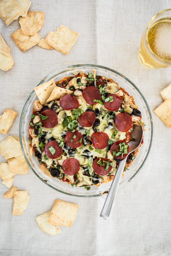 Layered Pepperoni Pizza Dip Recipe - a cheesy dip with artichokes, black olives, cream cheese, mozzarella, and basil that tastes just like a pepperoni pizza! The most delicious light appetizer!