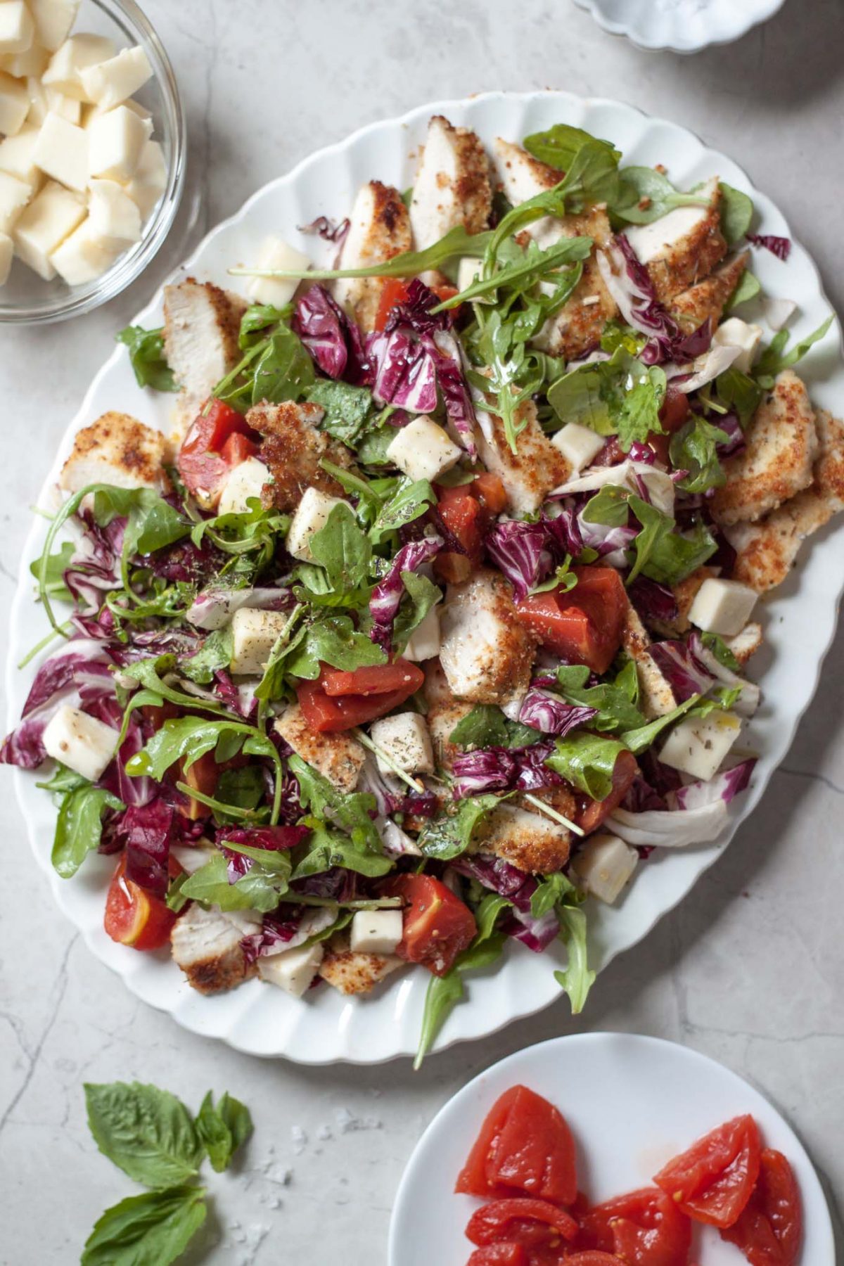 Parmesan Crusted Chicken Caprese Salad Recipe - A spruced up caprese salad made with arugula, radicchio, mozzarella, tomatoes, and crispy chicken cutlets breaded with almond meal and Parmesan!