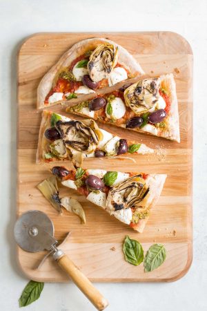 Grilled Artichoke, Olive and Pesto Flatbread Recipe - It's lighter than pizza (423 calories) and makes a better appetizer, too! Topped with kalamata olives, grilled artichokes, basil pesto, and mozzarella